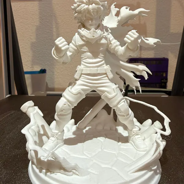 Figura de Deku, de My Hero Academia, impresa en 3D en blanc sense pintar, en pose de combat sobre una base amb efecte d'impacte