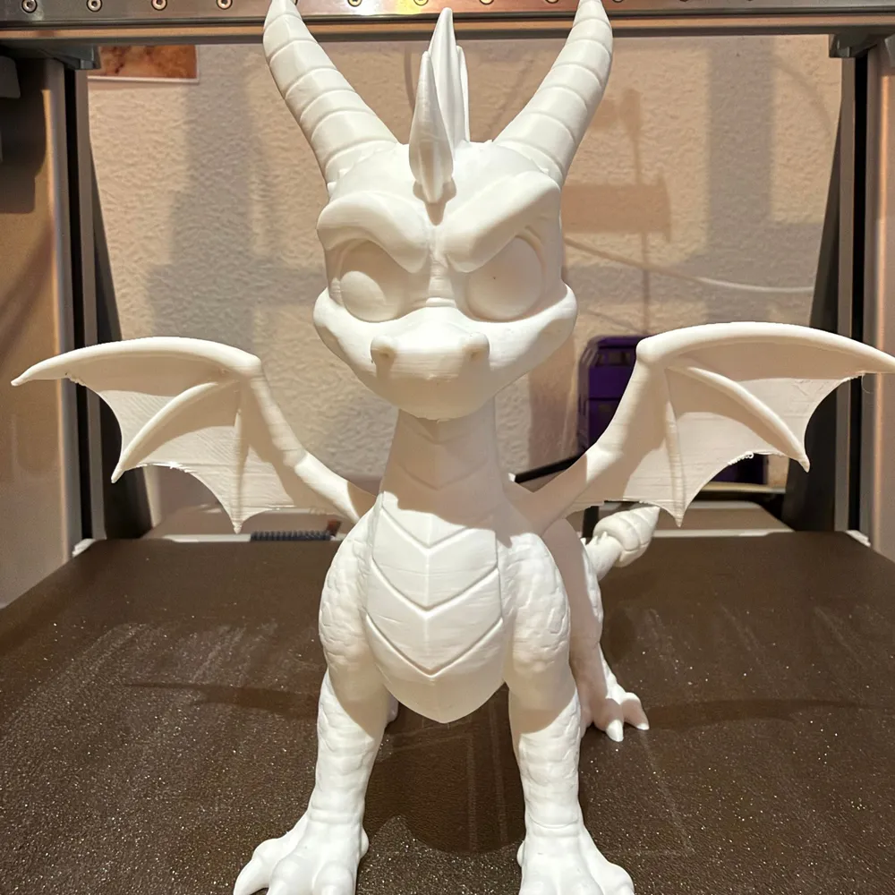Figura del drac Spyro impresa en 3D en blanc sense pintar, amb les ales i les banyes ben marcades