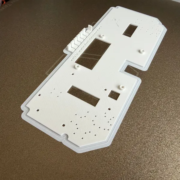 Maqueta impresa en 3D d'una consola, amb els forats de muntatge i les obertures per als comandaments